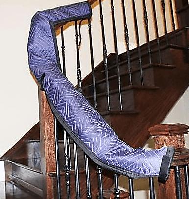 Moving Blankets wrapped around wooden railing of stairs