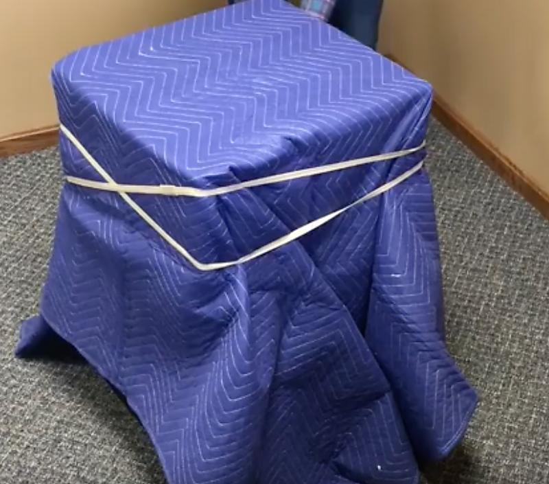 Blue Furniture Moving Pads in use wrapping around a mini fridge