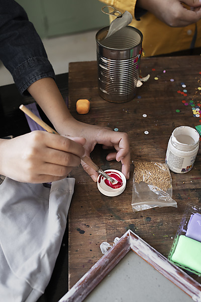 hands painting on wooden table