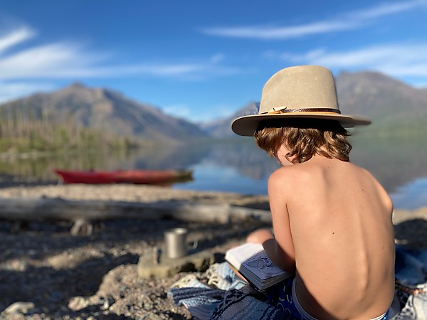 Boy reading by lake