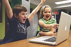 Excited boy and girl by laptop